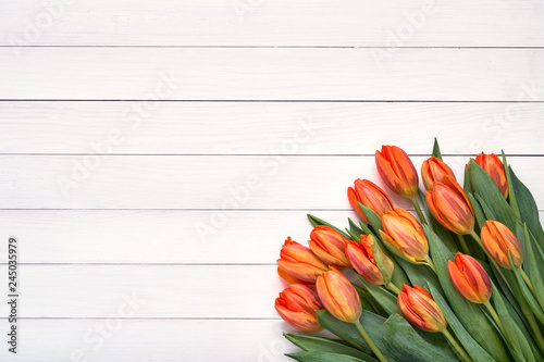 Bouquet of orange tulips on white wooden background. Top view, copy space. Holiday background, greeting card. #245035979