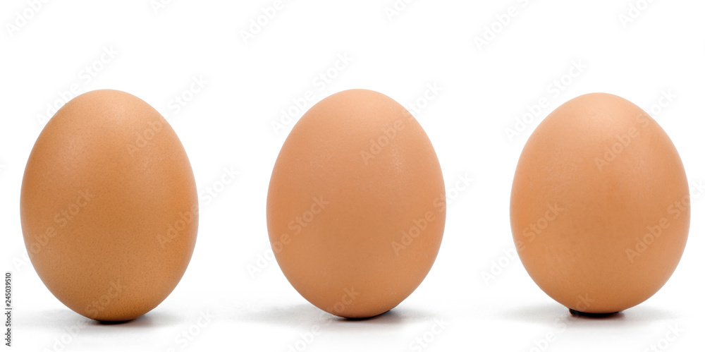 Three brown chicken eggs in a row against a white background. Three brown chicken eggs in a row against a white background.