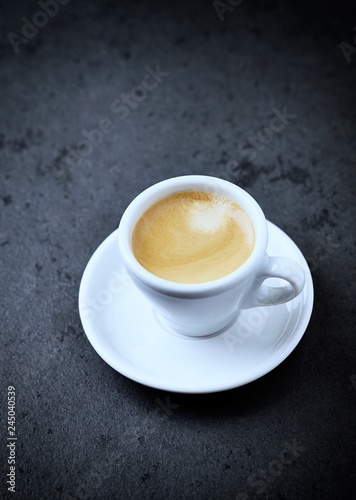 Cup of coffee on black stone background. Copy space.