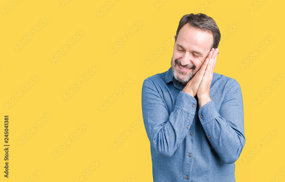 Handsome middle age elegant senior man over isolated background sleeping tired dreaming and posing with hands together while smiling with closed eyes. Handsome middle age elegant senior man over isolated background sleeping tired dreaming and posing with hands together while smiling with closed eyes.