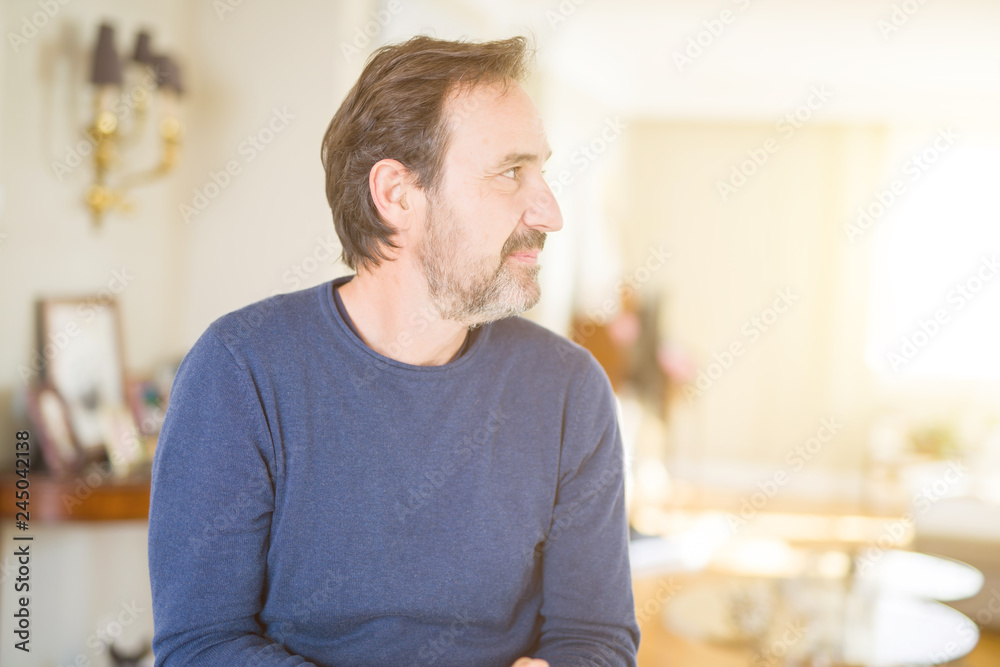 Handsome middle age man at home looking to side, relax profile pose with natural face with confident smile. Handsome middle age man at home looking to side, relax profile pose with natural face with confident smile.