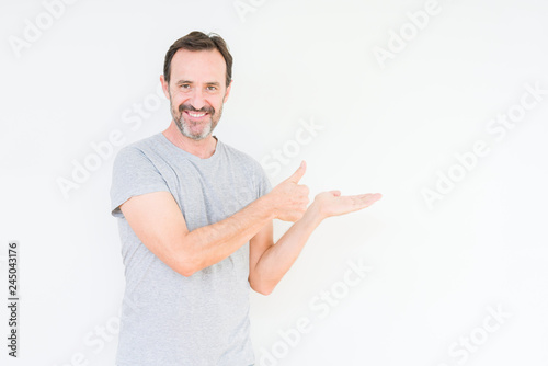 Handsome senior man over isolated background Showing palm hand and doing ok gesture with thumbs up, smiling happy and cheerful