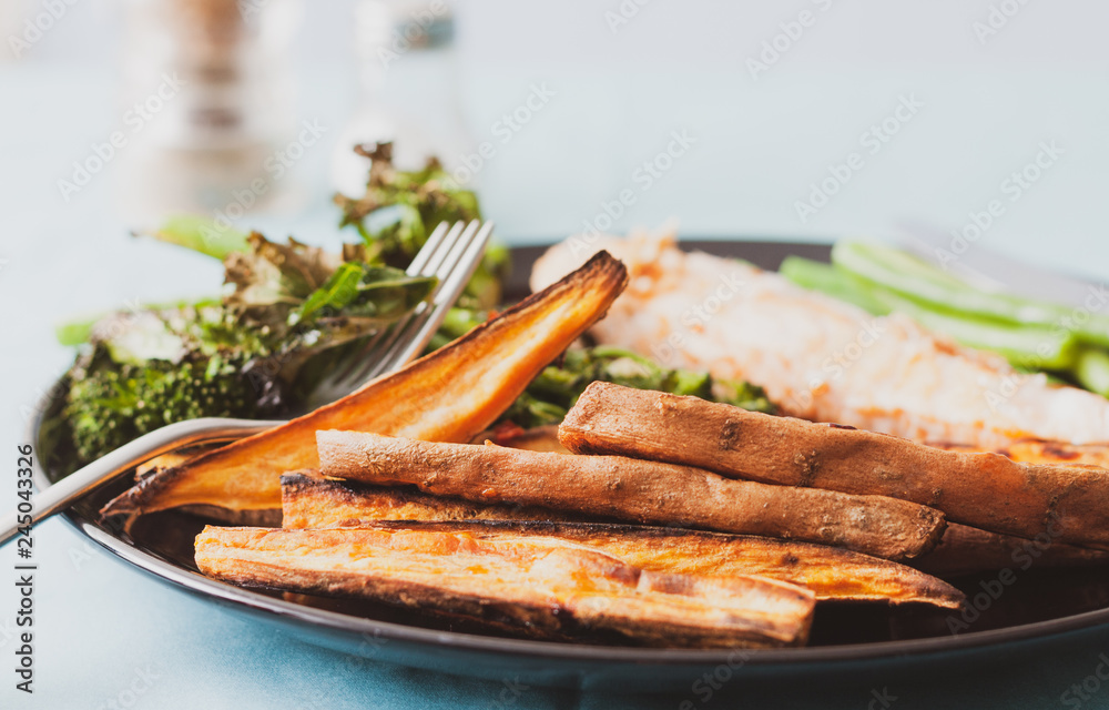 Sweet potato wedges and salmon fillet served with tenderstem broccoli and green beans Sweet potato wedges and salmon fillet served with tenderstem broccoli and green beans
