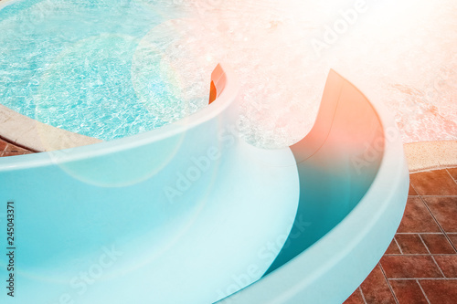 Stylishly interesting water slide in the pool near the sea on nature background