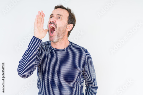 Handsome senior man over isolated background shouting and screaming loud to side with hand on mouth. Communication concept.