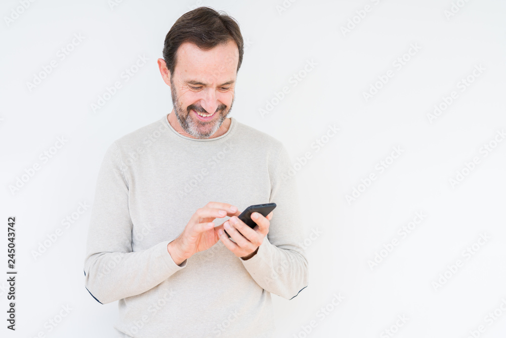 Senior man using smartphone over isolated background with a happy face standing and smiling with a confident smile showing teeth Senior man using smartphone over isolated background with a happy face standing and smiling with a confident smile showing teeth