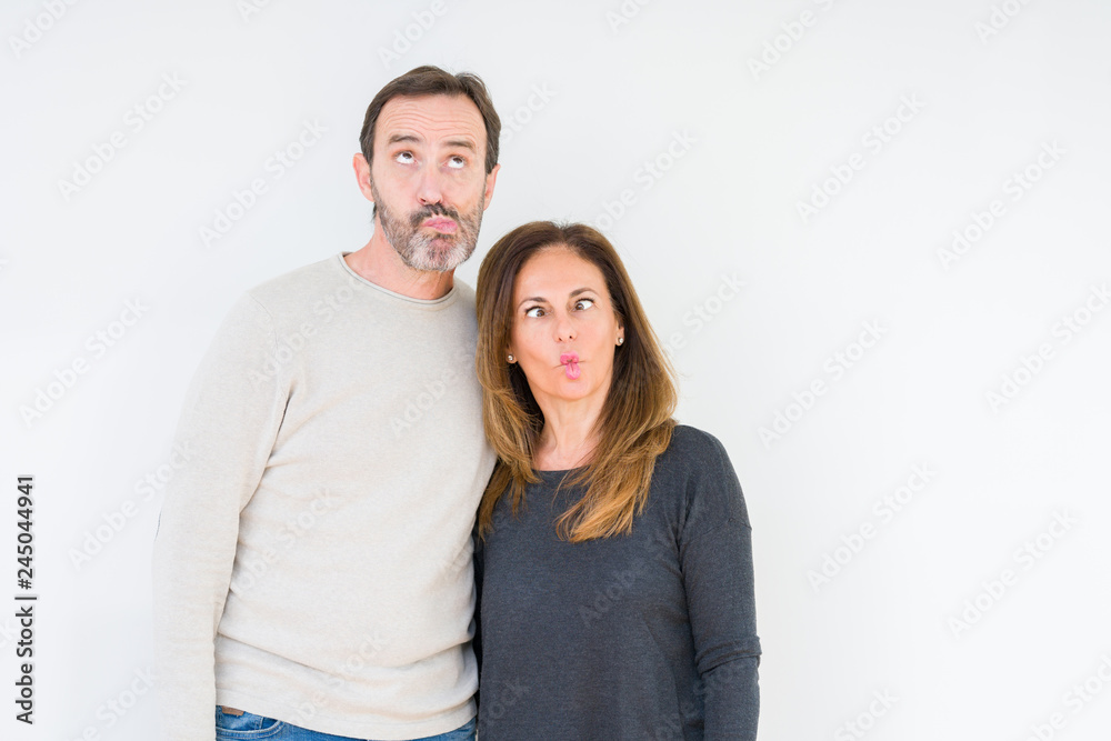 Beautiful middle age couple in love over isolated background making fish face with lips, crazy and comical gesture. Funny expression. Beautiful middle age couple in love over isolated background making fish face with lips, crazy and comical gesture. Funny expression.