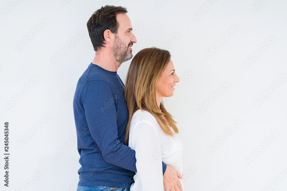 Beautiful middle age couple in love over isolated background looking to side, relax profile pose with natural face with confident smile. Beautiful middle age couple in love over isolated background looking to side, relax profile pose with natural face with confident smile.