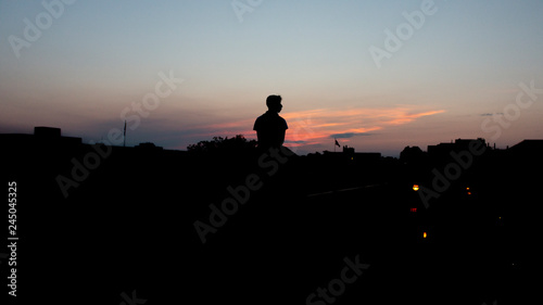 silhouette of man on top of ledge