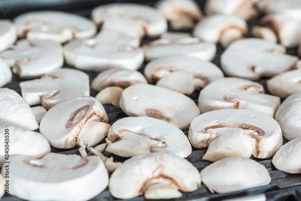 Sliced champignons mushrooms grilled on electric grill or BBQ close up view