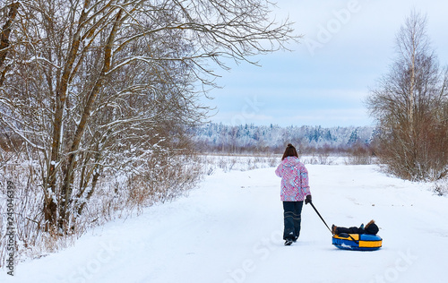 a young mother rolls a small child in the winter in the Park. Russian winter.