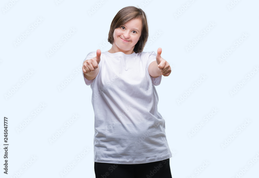 Young adult woman with down syndrome over isolated background approving doing positive gesture with hand, thumbs up smiling and happy for success. Looking at the camera, winner gesture. Young adult woman with down syndrome over isolated background approving doing positive gesture with hand, thumbs up smiling and happy for success. Looking at the camera, winner gesture.