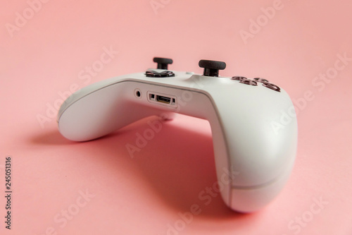 White joystick gamepad, game console on pink colourful trendy modern fashion pin-up background. Computer gaming competition videogame control confrontation concept. Cyberspace symbol