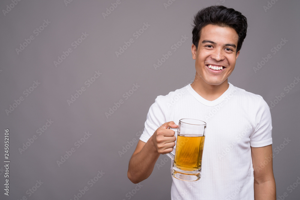 Portrait of young Asian man against gray background Portrait of young Asian man against gray background