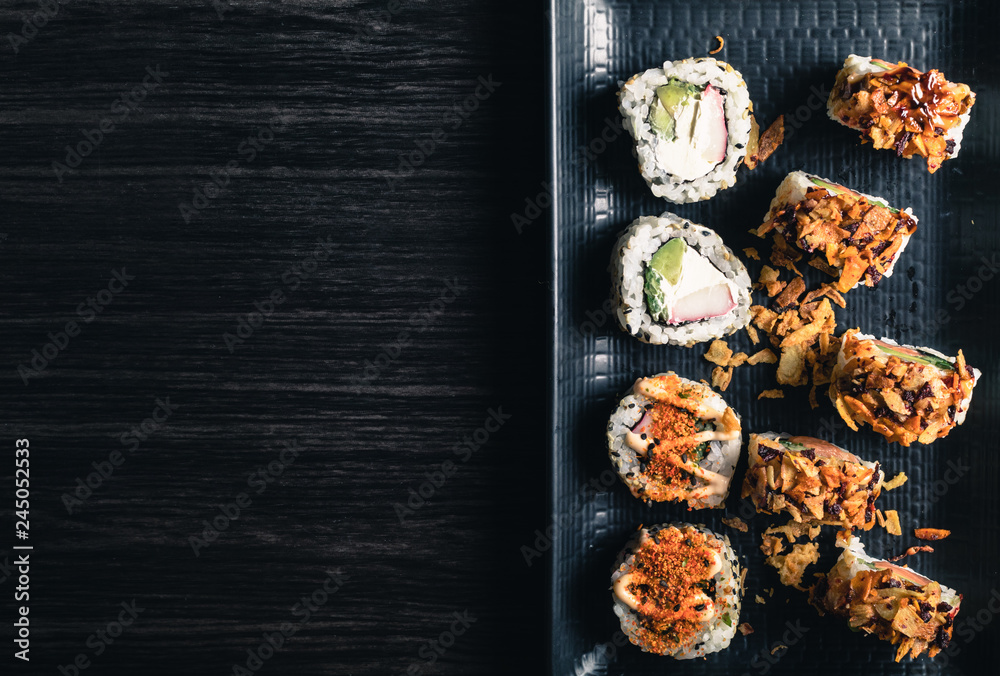 Fototapeta premium close up of sushi rolls on black tray. Copy space