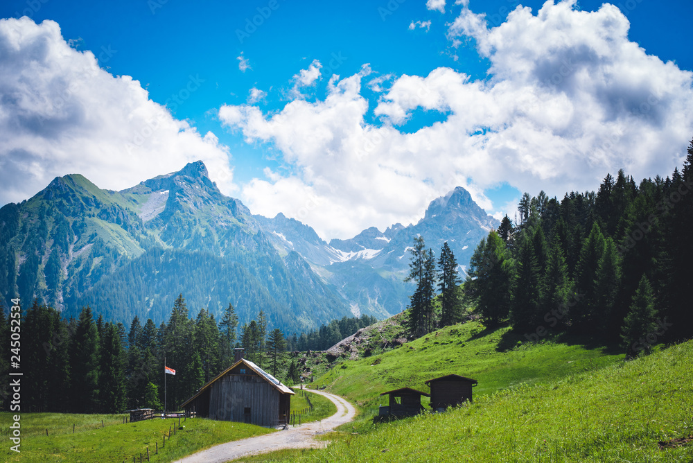 Landschaftsbild mit Bergen und einer Hütte