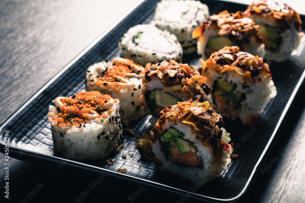 close up of sushi rolls on black tray close up of sushi rolls on black tray