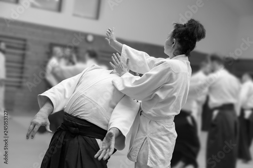 Man and woman practice aikido in martial arts school