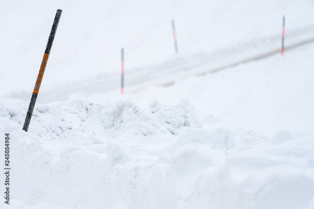 Holzschneestangen neben der Straße im Winter Holzschneestangen neben der Straße im Winter