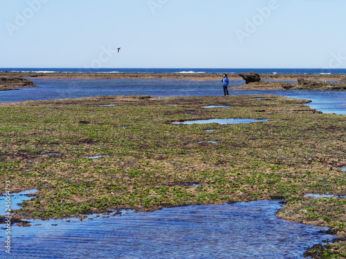 Obraz na płótnie Young woman walking on the rocky coast of Patagonia w salonie