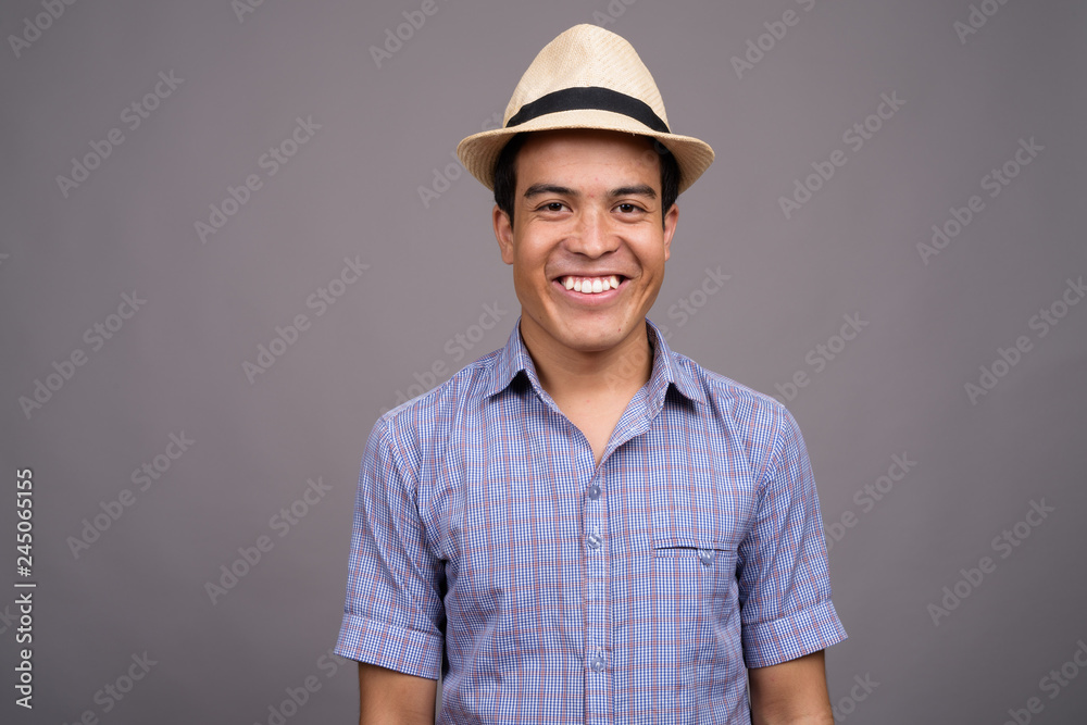 Young Asian tourist man ready for vacation against gray backgrou