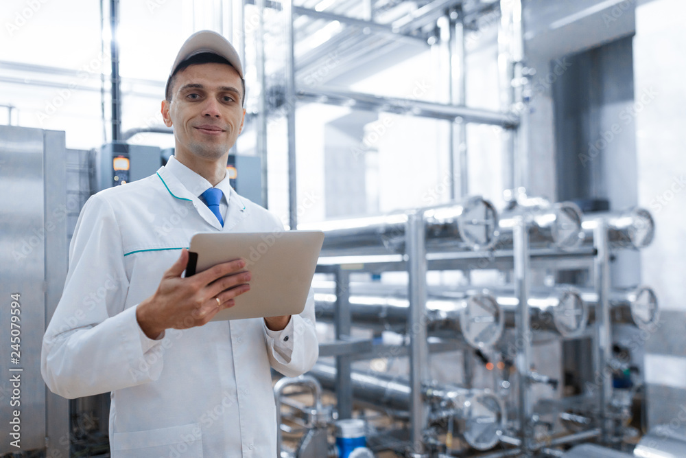 Technologist with a tablet in his hands at the dairy plant Technologist with a tablet in his hands at the dairy plant