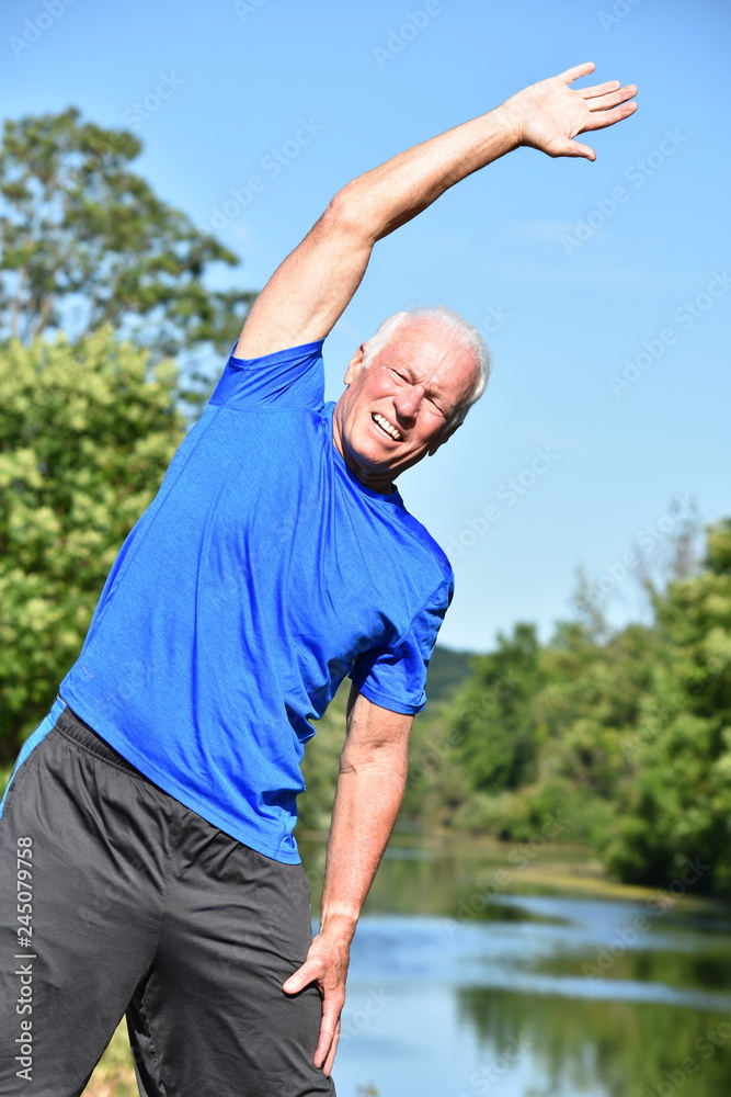 Naklejka premium Athletic Male Senior Stretching By River