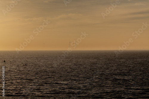 Windräder an der Küste im Nebel