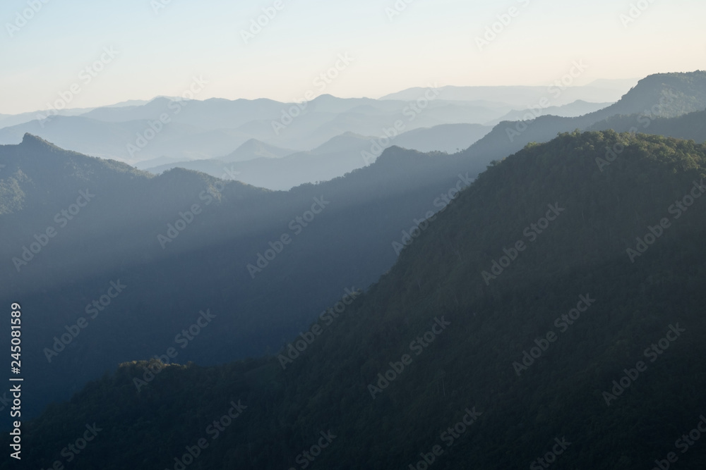 Naklejka premium Mountain layer with sun ray scenic landscape morning in bright sky.