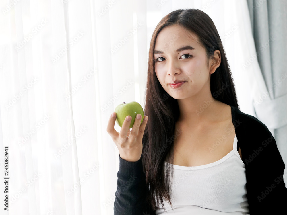 Asian pregnant woman holding green apple near window, lifestyle concept. Asian pregnant woman holding green apple near window, lifestyle concept.