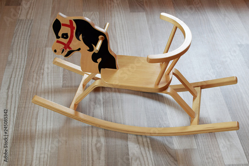 Wallpaper Mural Cute wooden plywood rocking horse on brown wood texture laminate floor indoors. Children retro toy. Torontodigital.ca