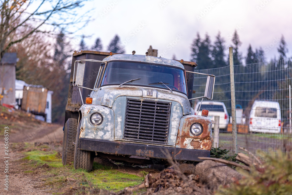 Hillsboro, Oregon \ USA - December 02 2018: Abandoned old rusty Harvest International Loadstart truck a farm field. The truck has extra logo modded by the owner above the radiator grill - Grandokee