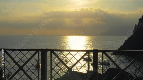 Sunset by handrail over sea in Italy. photo