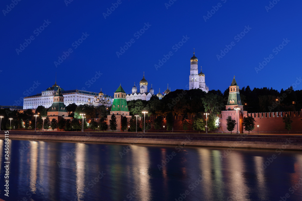 View of a Moscow Kremlin at night. Cathedral of Annunciation, Cathedral of Archangel, Ivan the Great Bell-tower and Big Kremlin Palace behind Kremlin wall from Sofiyskaya embankment.