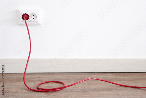 Power cord cable plugged into wall outlet