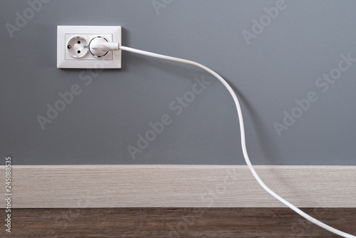 Schilderij op canvas Power cord cable plugged into wall outlet
