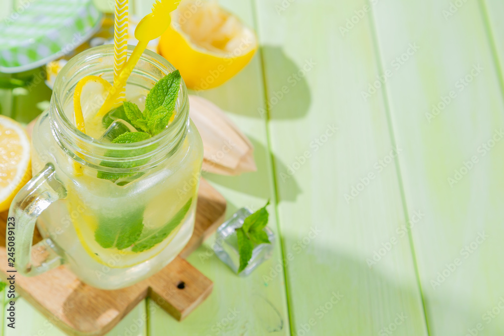 Fototapeta premium Summer lemonade on wood background, harsh light, copy space