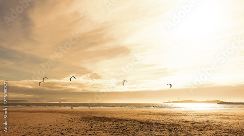 Kite surfers glide on the waves of the Atlantic ocean. Panoramic landscape