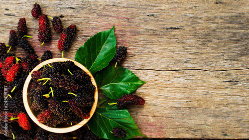 Mulberries fruits in wooden bowl on wood backgrounds above