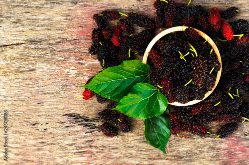 Mulberries fruits in bowl on wood backgrounds above for your text