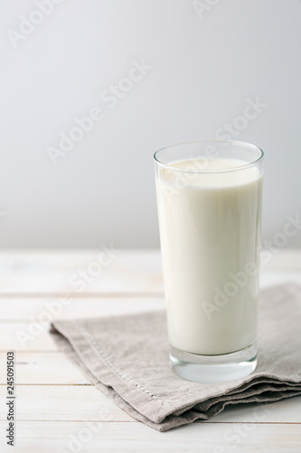 Glass of milk on white rustic wooden background
