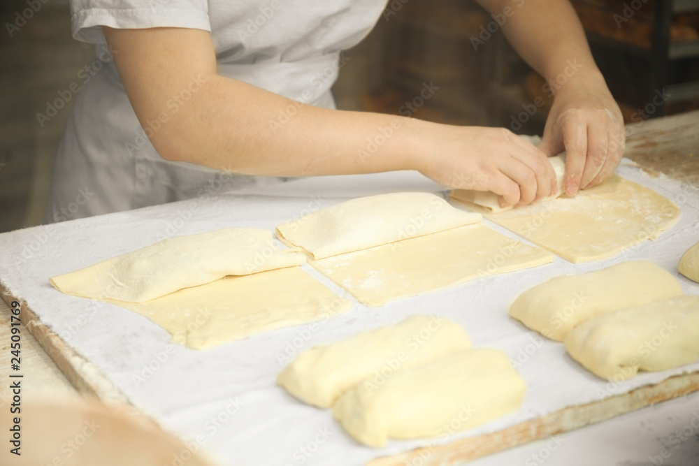 Hands of the cook gently knead dough. Little family bakery.