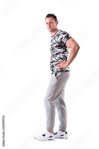 Side view of confident athletic sportsman posing with hands on hips. Full body isolated on white background. © sharplaninac
