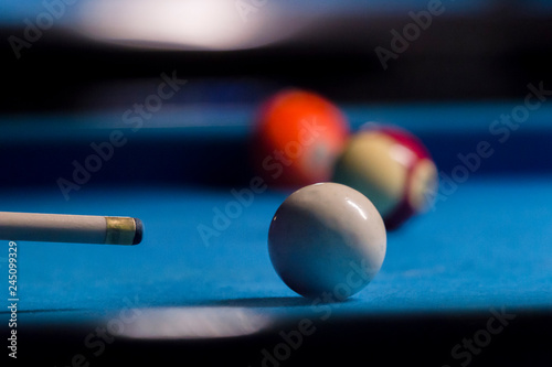 Playing billiard. Billiards balls and cue on blue billiards tabl