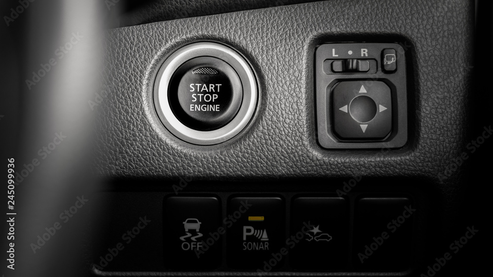 close up of a pressing the start/stop engine button at a car.