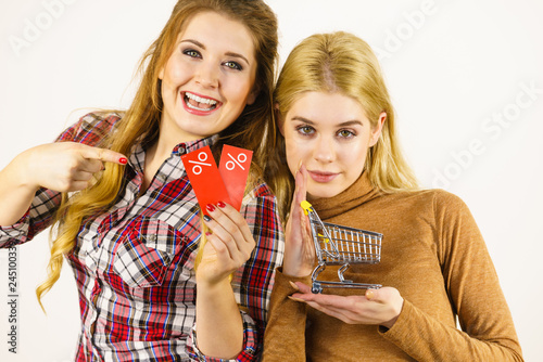 Two women shopping cart with sale photo