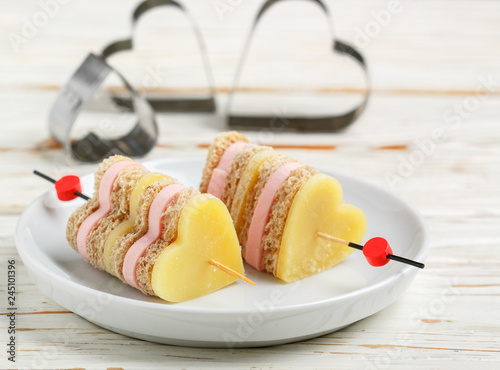 Mini sandwiches parmesan cheese ham bread on skewers in the form of hearts. Valentine's day. Breakfast for loved ones. Selective focus and copy space