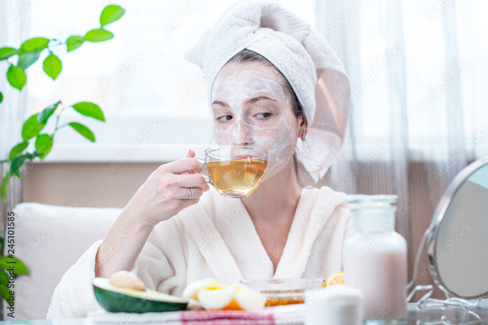 Beautiful happy young woman with natural cosmetic mask on her face. Concept skin care and Spa treatments Beautiful happy young woman with natural cosmetic mask on her face. Concept skin care and Spa treatments
