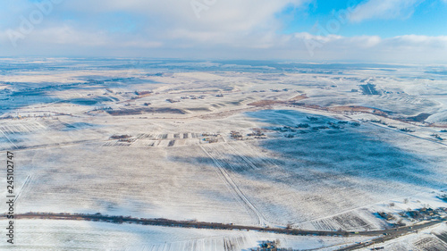 Aerial view of winter land with forests, white fields, in winter on an overcast day. © Ruslan Ivantsov