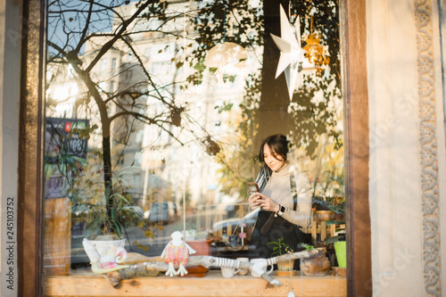 young girl standing at the big window looking outside